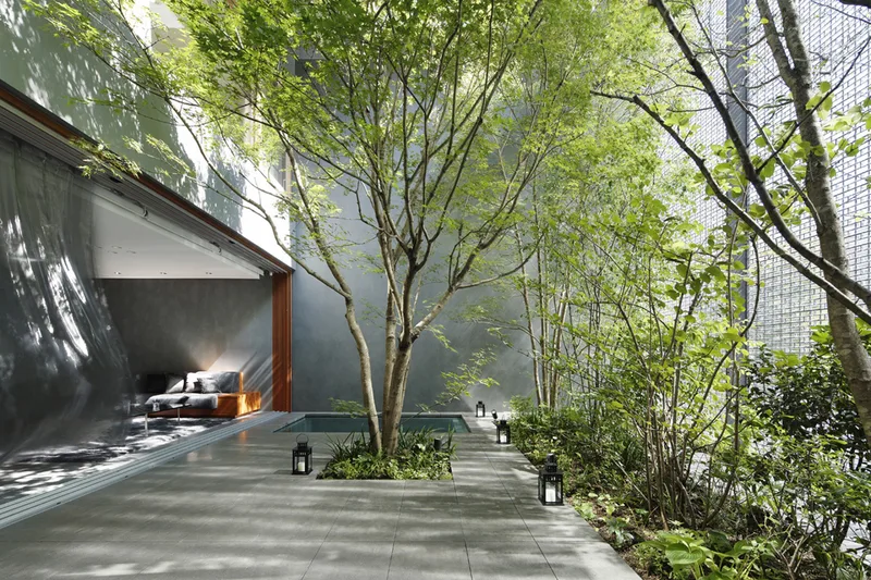 The garden courtyard of the Optical Glass House, with the glass-block wall along one side