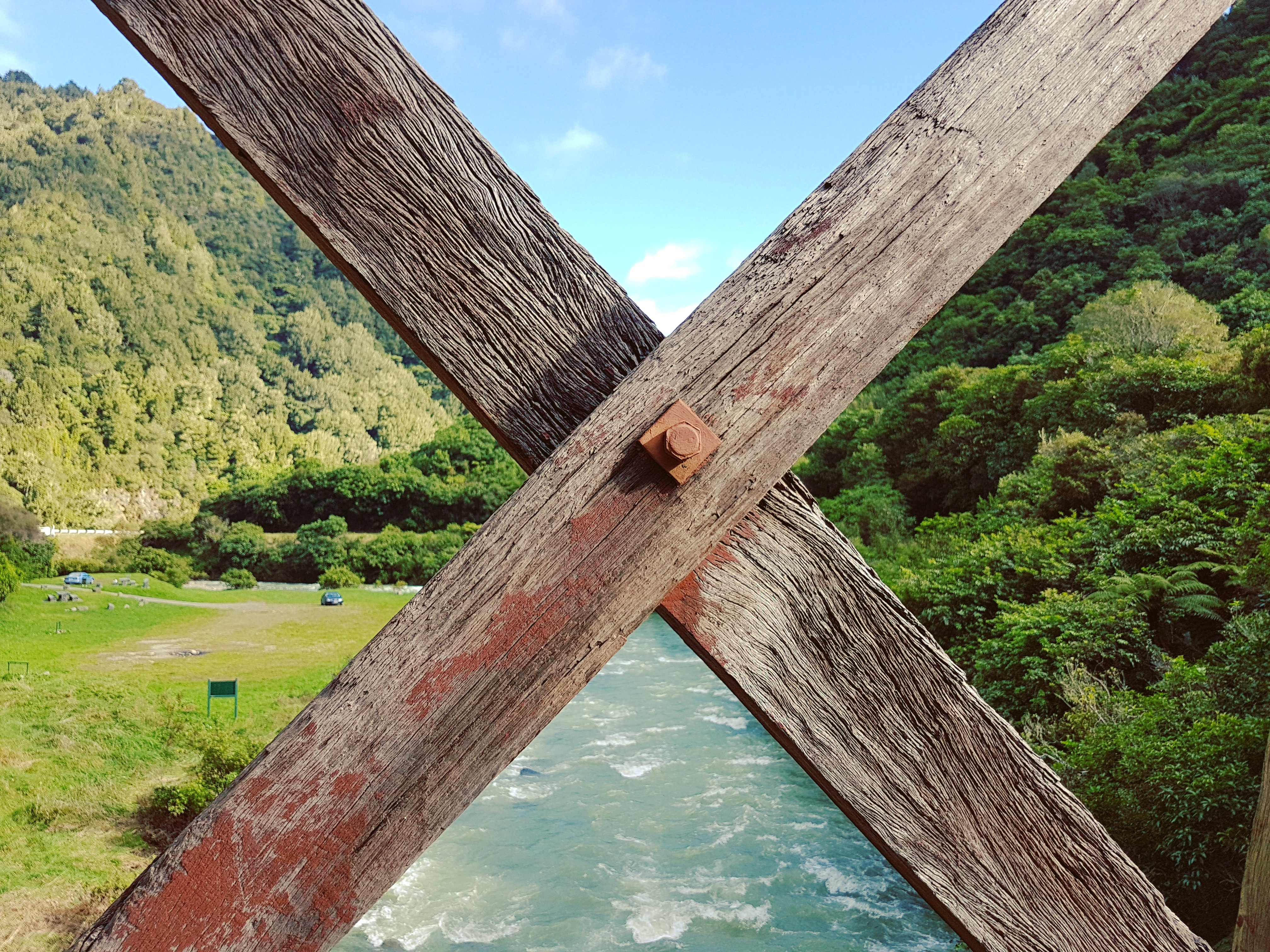 Crossed wooden beams of a bridge over a turquoise river