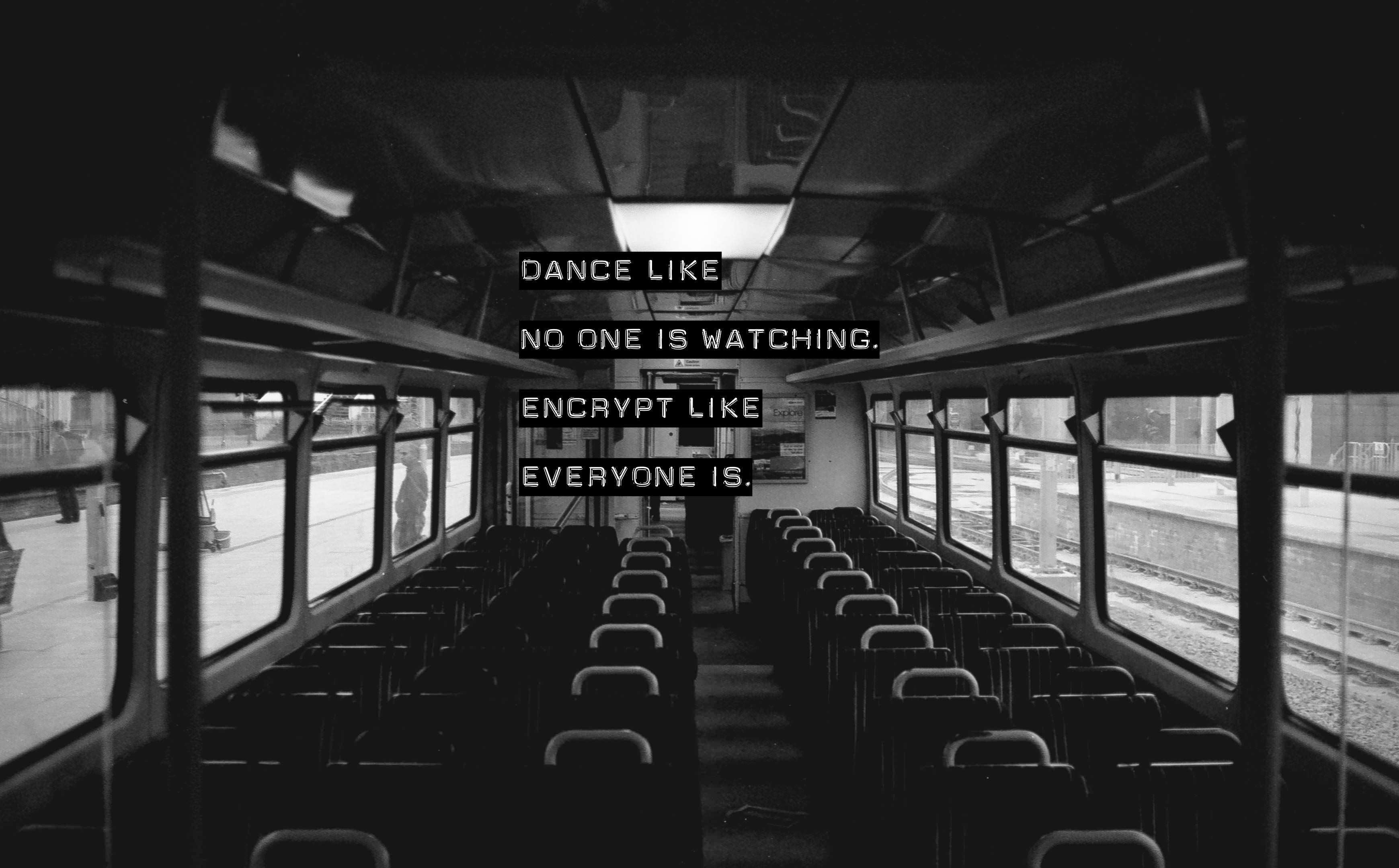 Empty train interior with text: Dance like no one is watching, Encrypt like everyone is