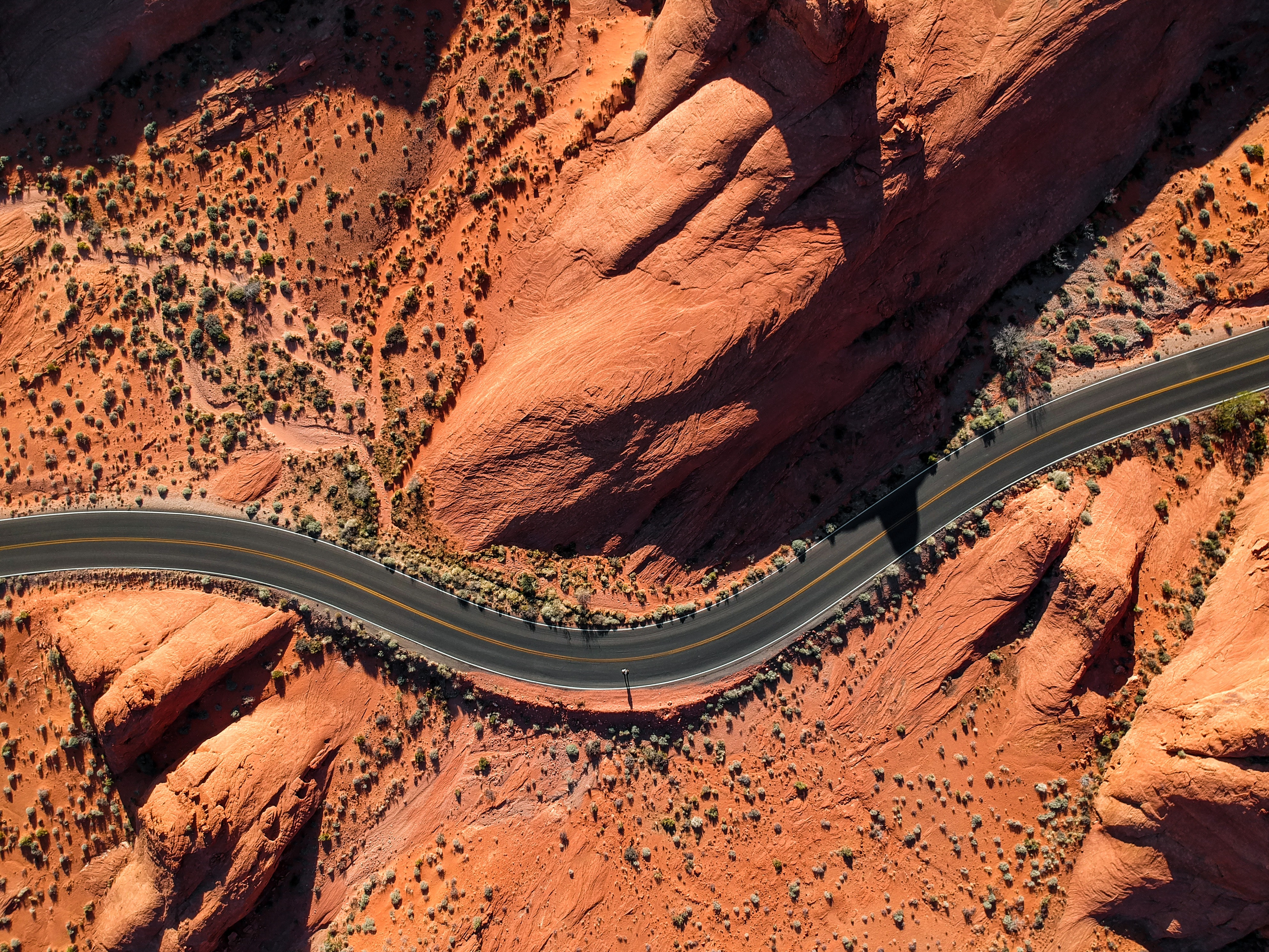 Aerial view of a road winding through red rock canyons