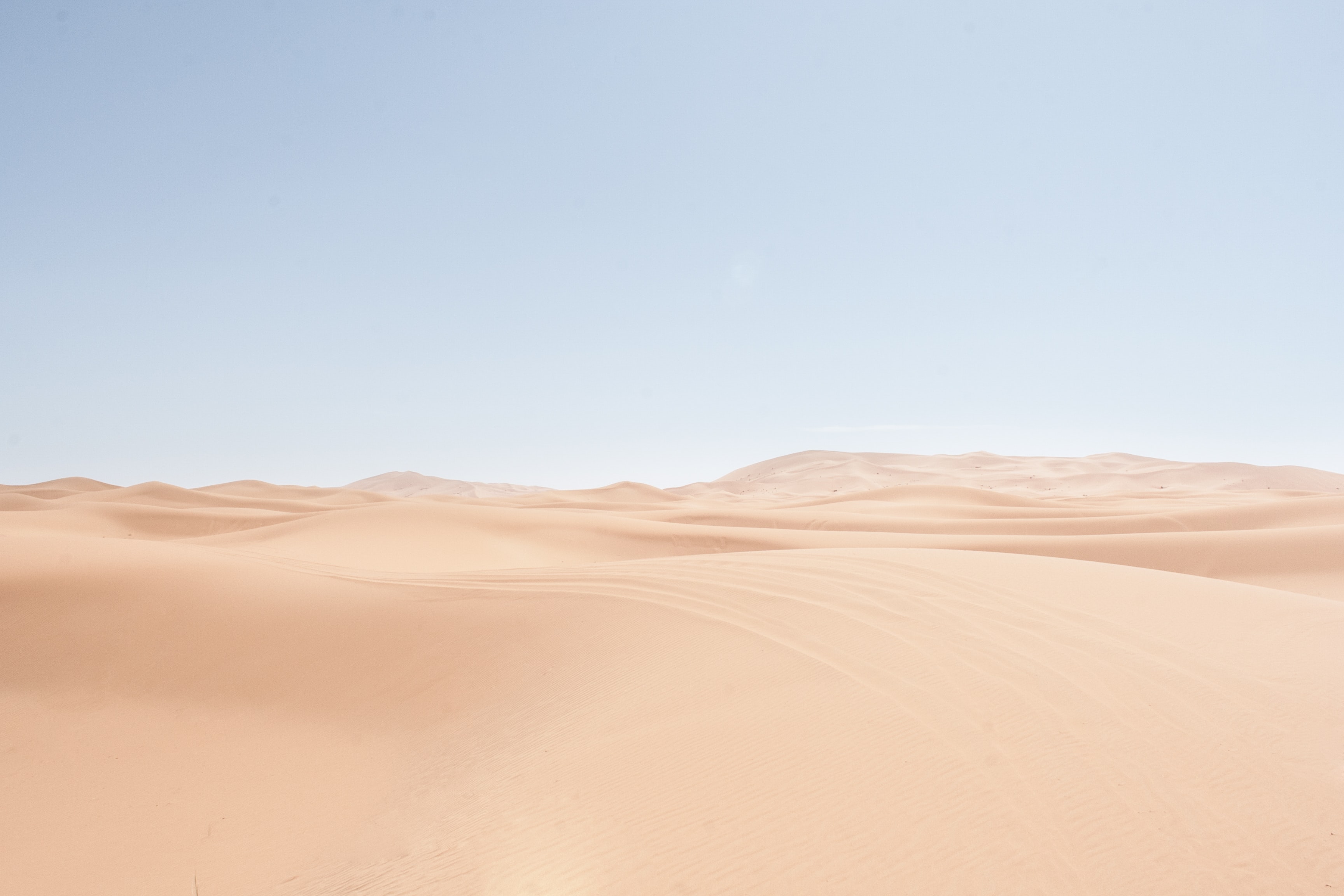 Pale sand dunes under a hazy sky