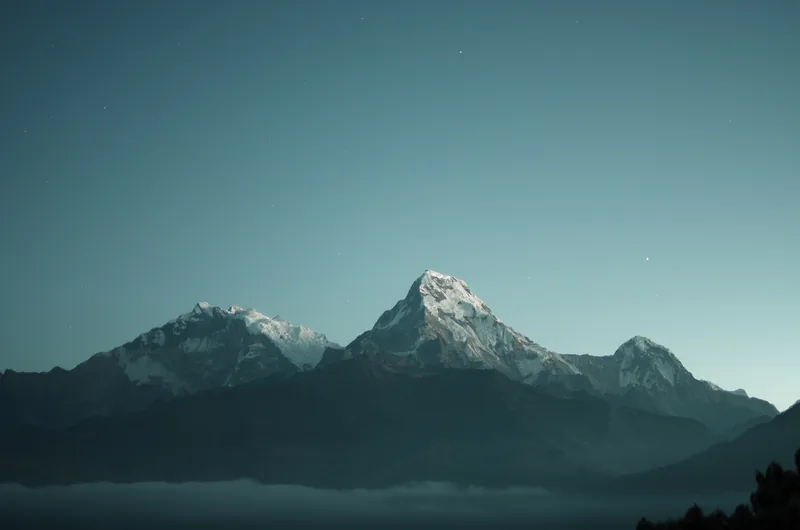 Mountain peaks under a starry night sky
