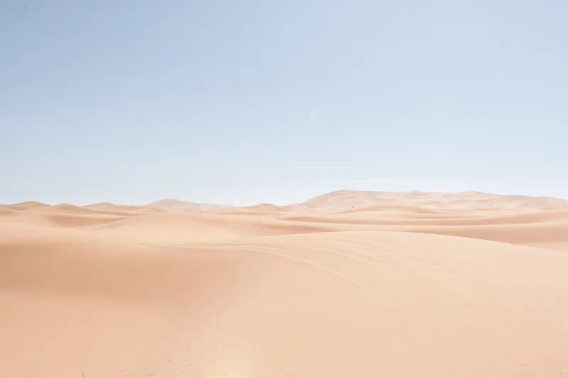 Pale sand dunes under a hazy sky