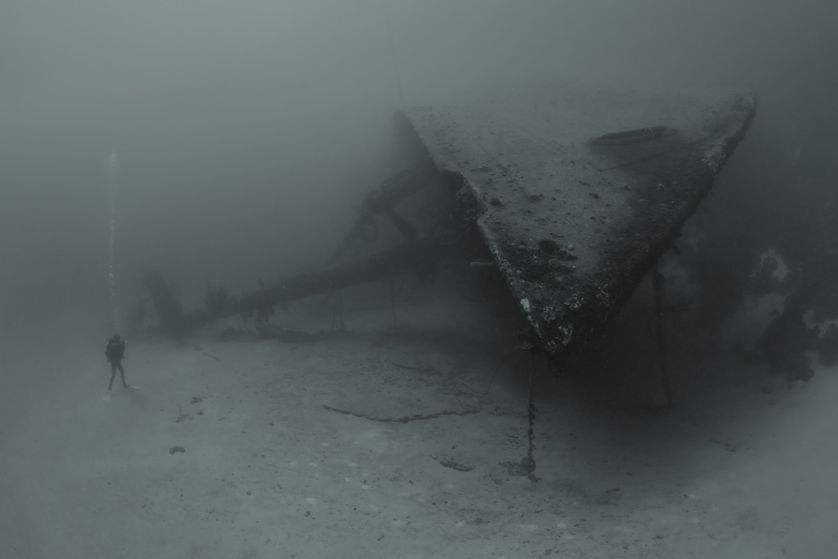 Diver next to a shipwreck underwater