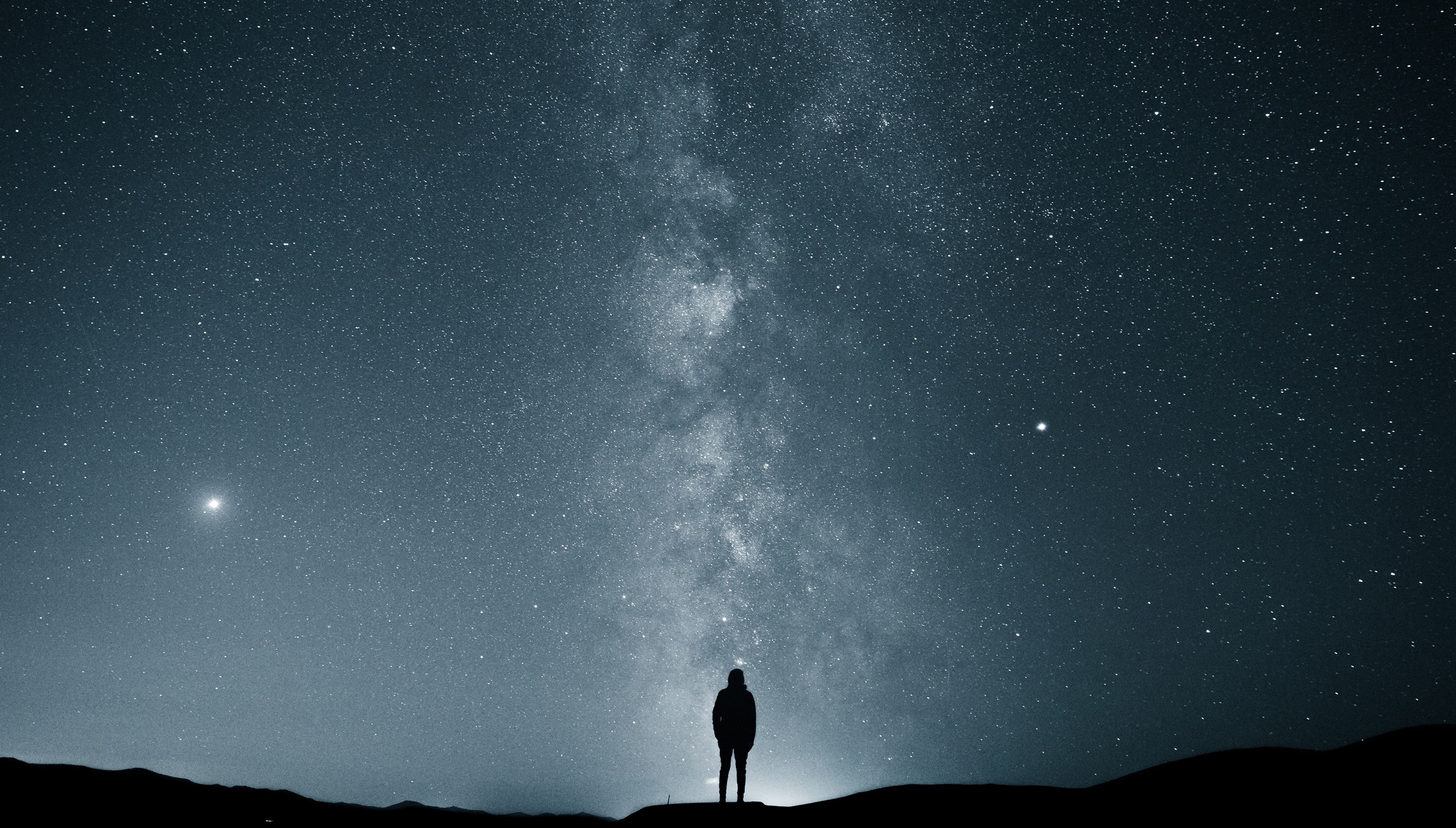 Silhouette of a person under the Milky Way